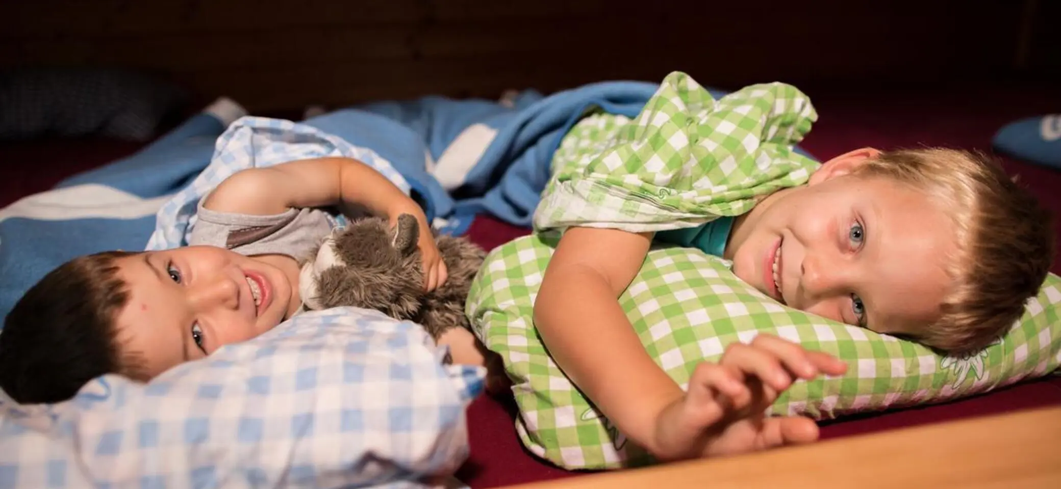 Kinder kuscheln sich in ein Hüttenbett | © DAV / Jens Klatt